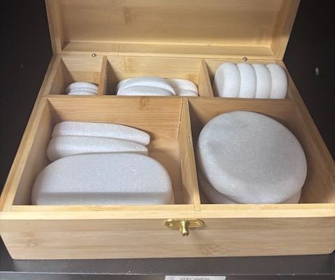 A wooden box filled with white stones on a table.