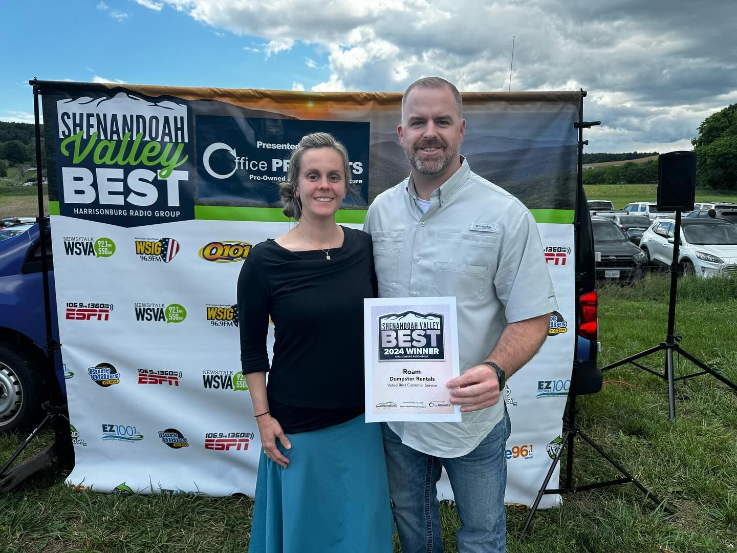 A man and a woman are standing in front of a sign that says valley best.