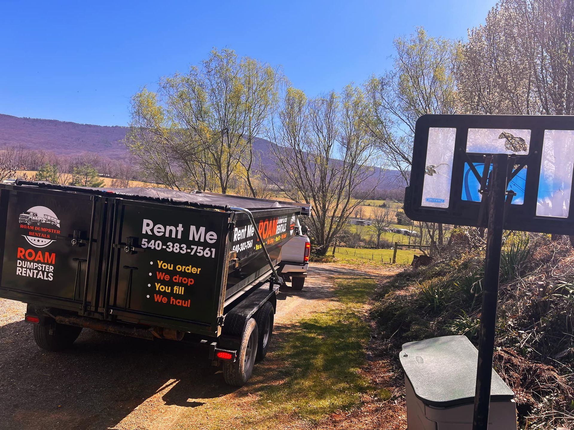 A rent me dumpster is parked on the side of the road