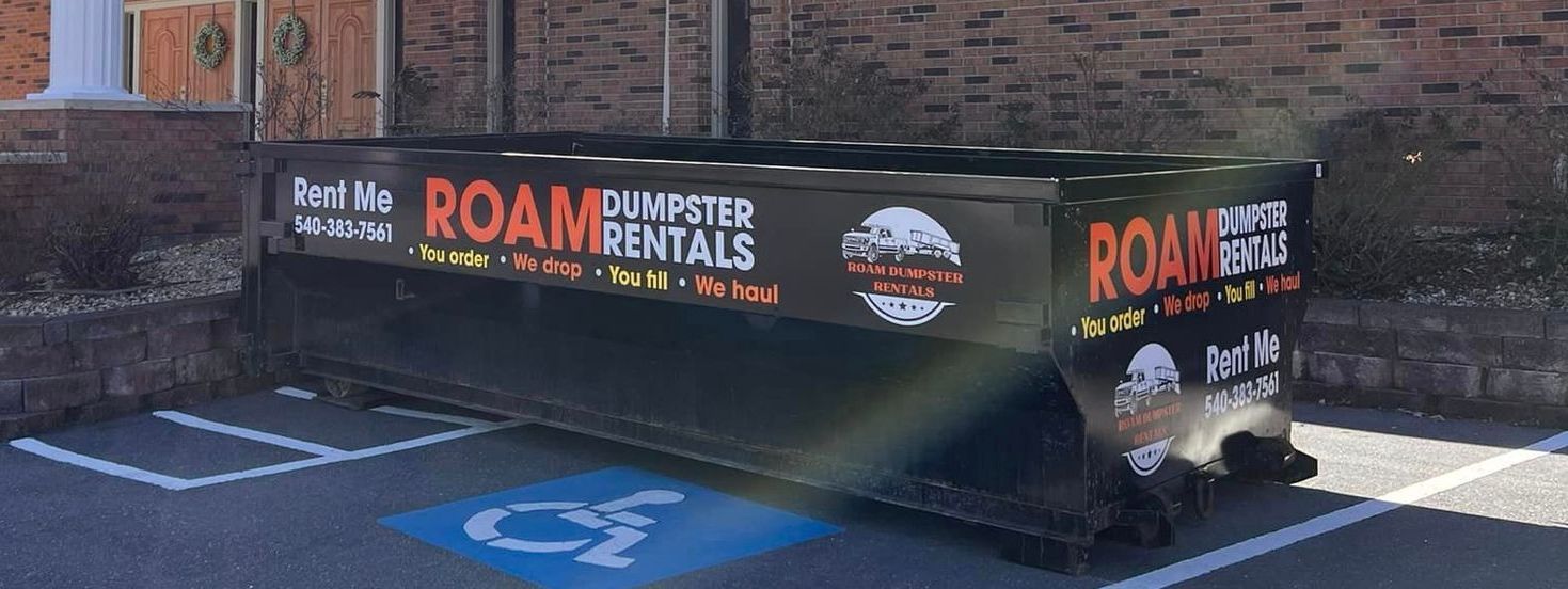 A dumpster is parked in a handicapped parking spot.