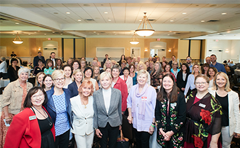 A large group of people are posing for a picture in a room.