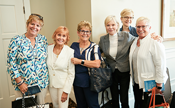 A group of women are posing for a picture together in a room.