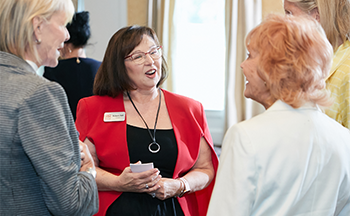 A group of women are talking to each other in a room.