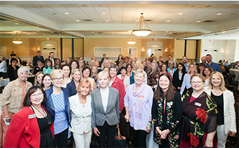 A large group of people are posing for a picture in a room.