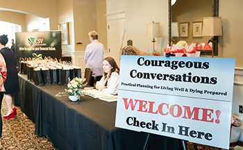 A sign that says courageous conversations welcome check in here