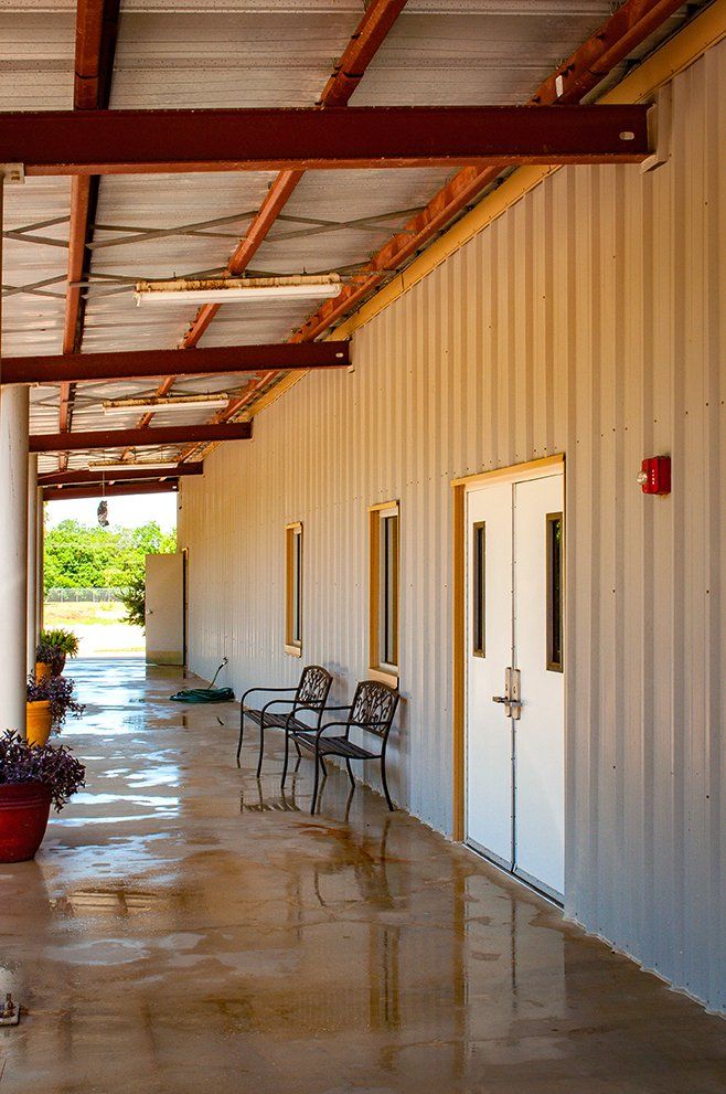 a long hallway with chairs and doors in a building