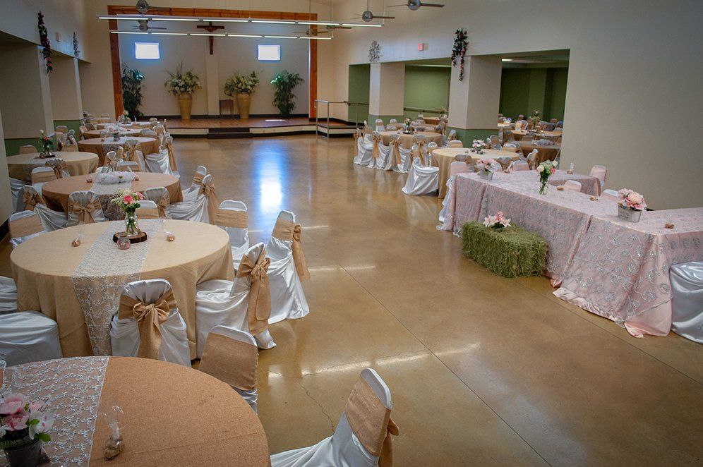 a large room with tables and chairs set up for a wedding reception .