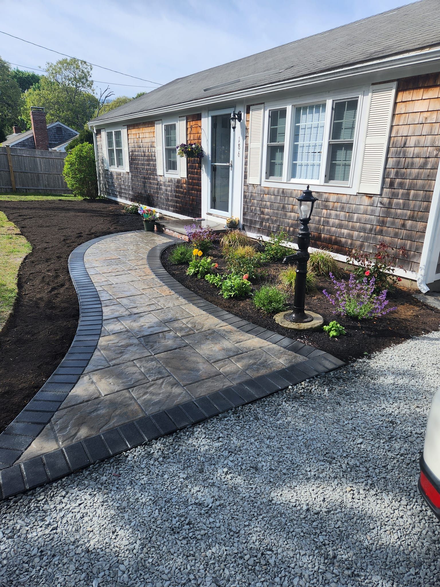 There is a walkway leading to the front of the house.