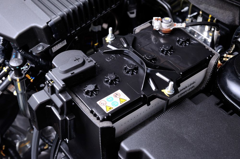 A Car Battery is Sitting Under the Hood of a Car — Norm Beatty's Auto Electrical Service In Bateau Bay, NSW
