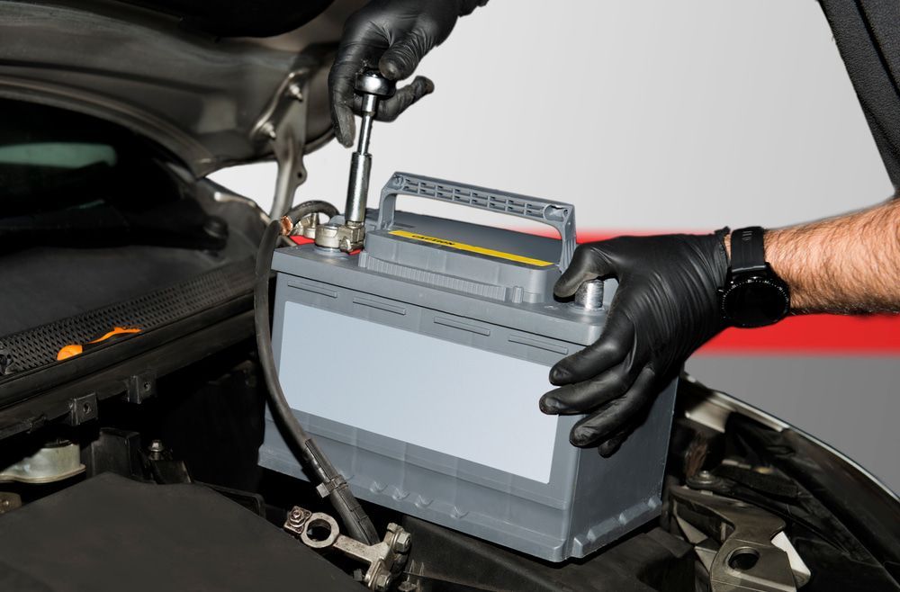 A Person Using a Wrench to Install a Car Battery — Norm Beatty's Auto Electrical Service In Long Jetty, NSW