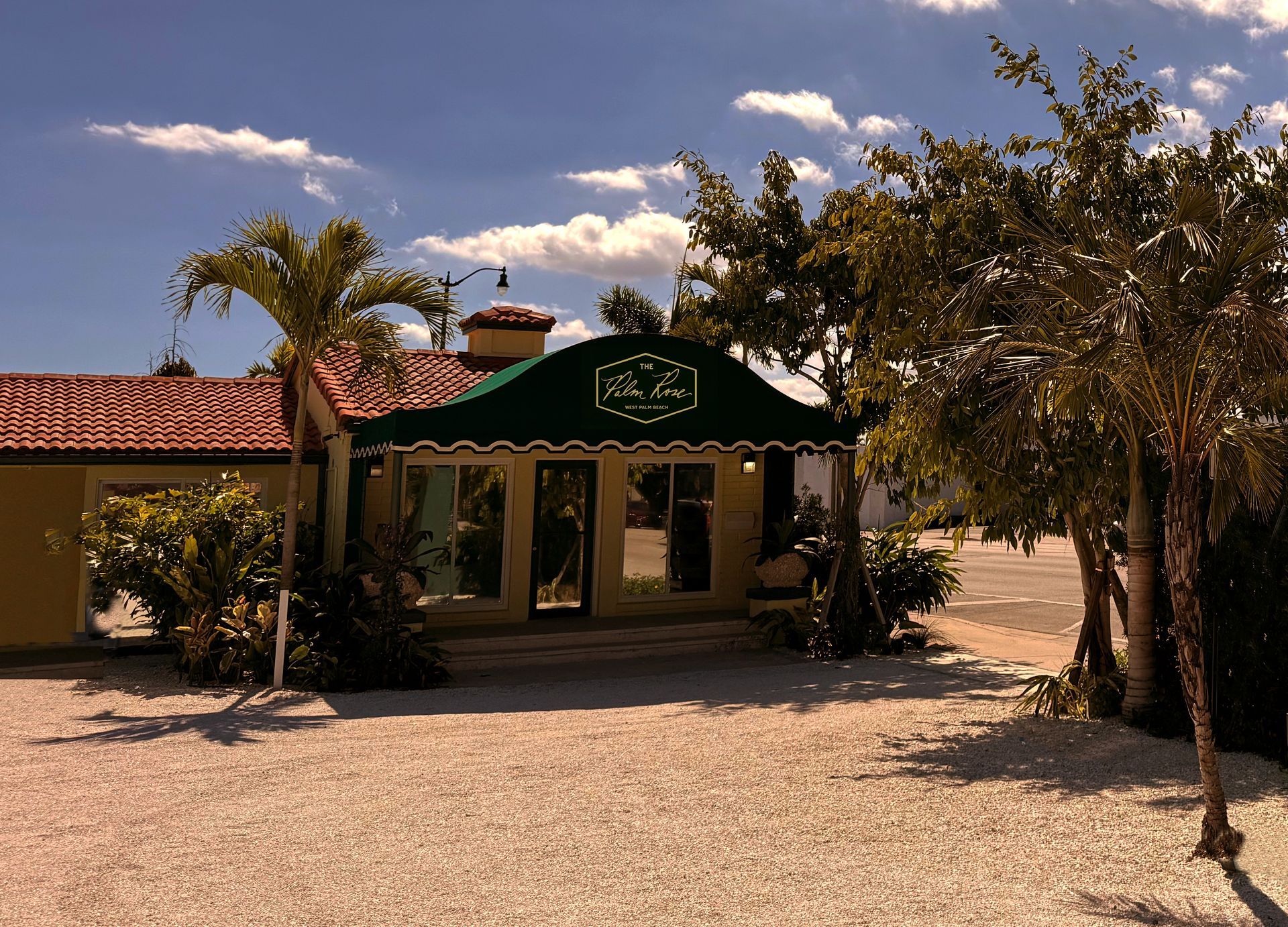 Sign for Angler's Motel & Lodge; cream-colored, with a yellow building and light blue sky.