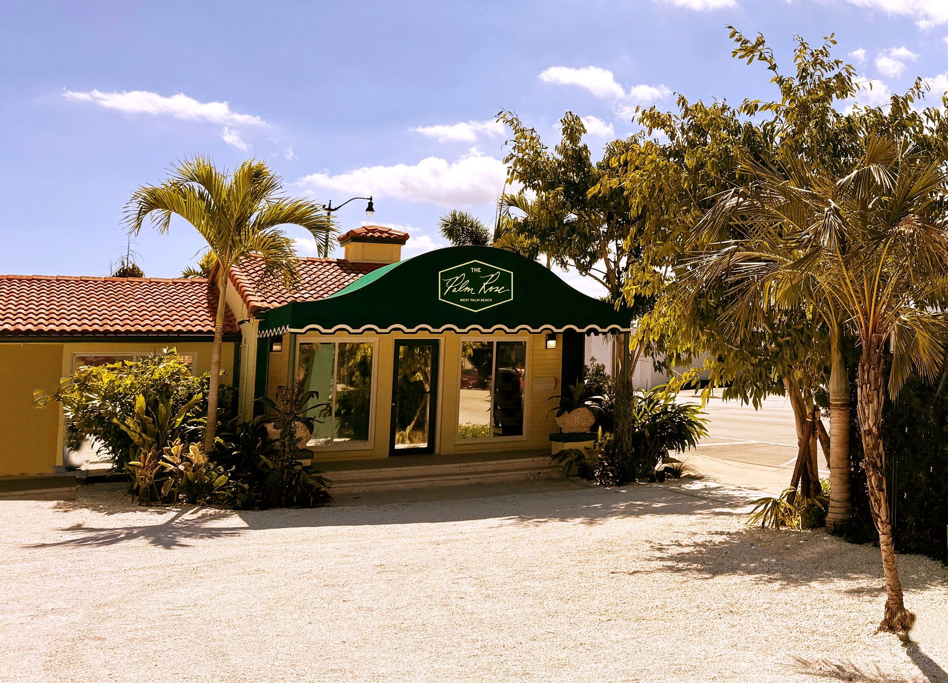Sign for Angler's Motel & Lodge; cream-colored, with a yellow building and light blue sky.