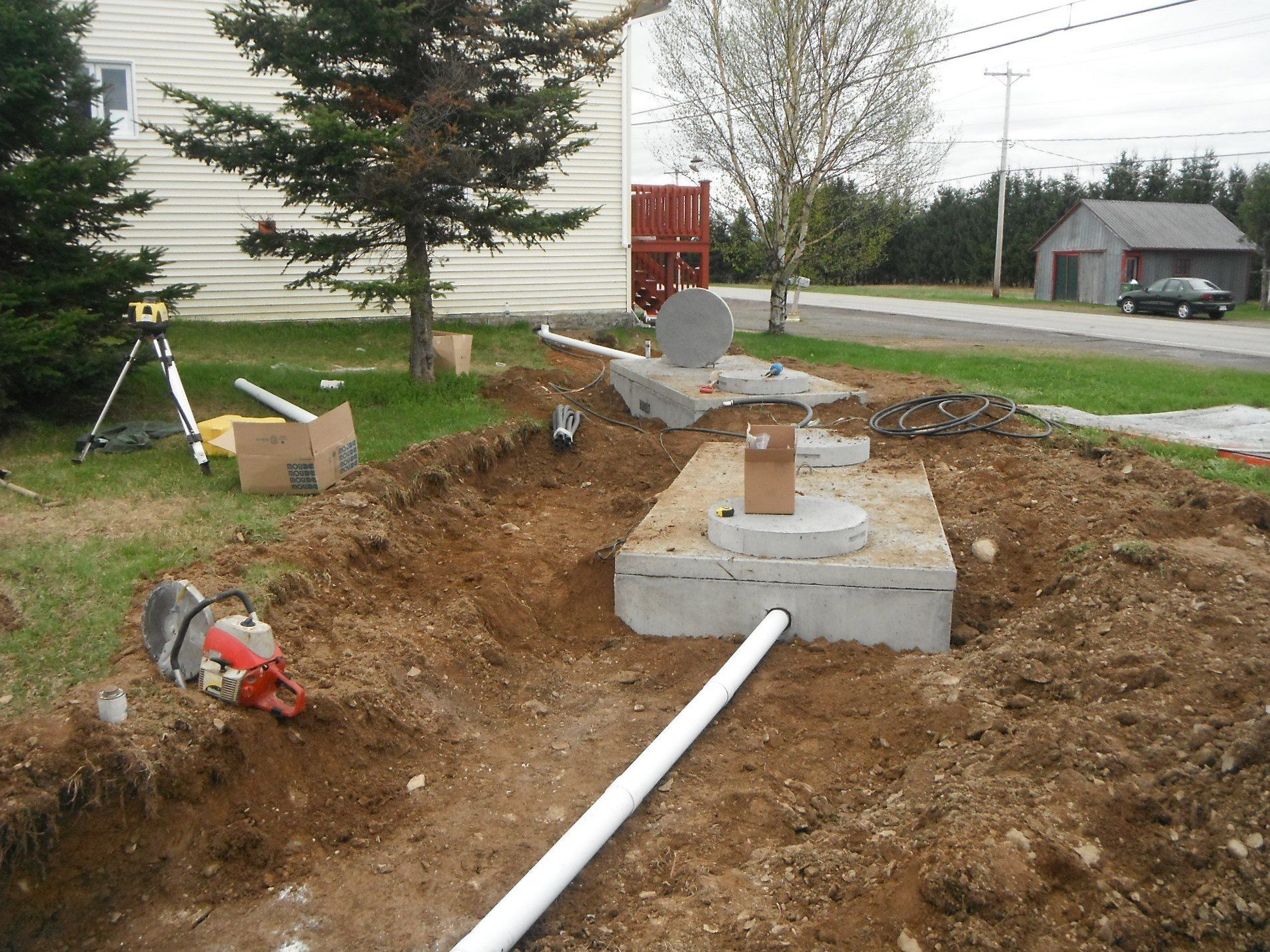 2 fosses septiques à moitié enfouies dans le sol