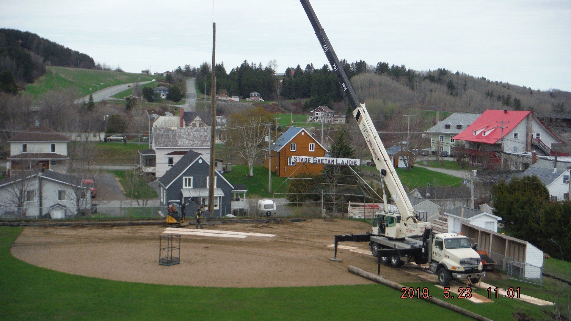 camion-grue qui installe un poteau de téléphone