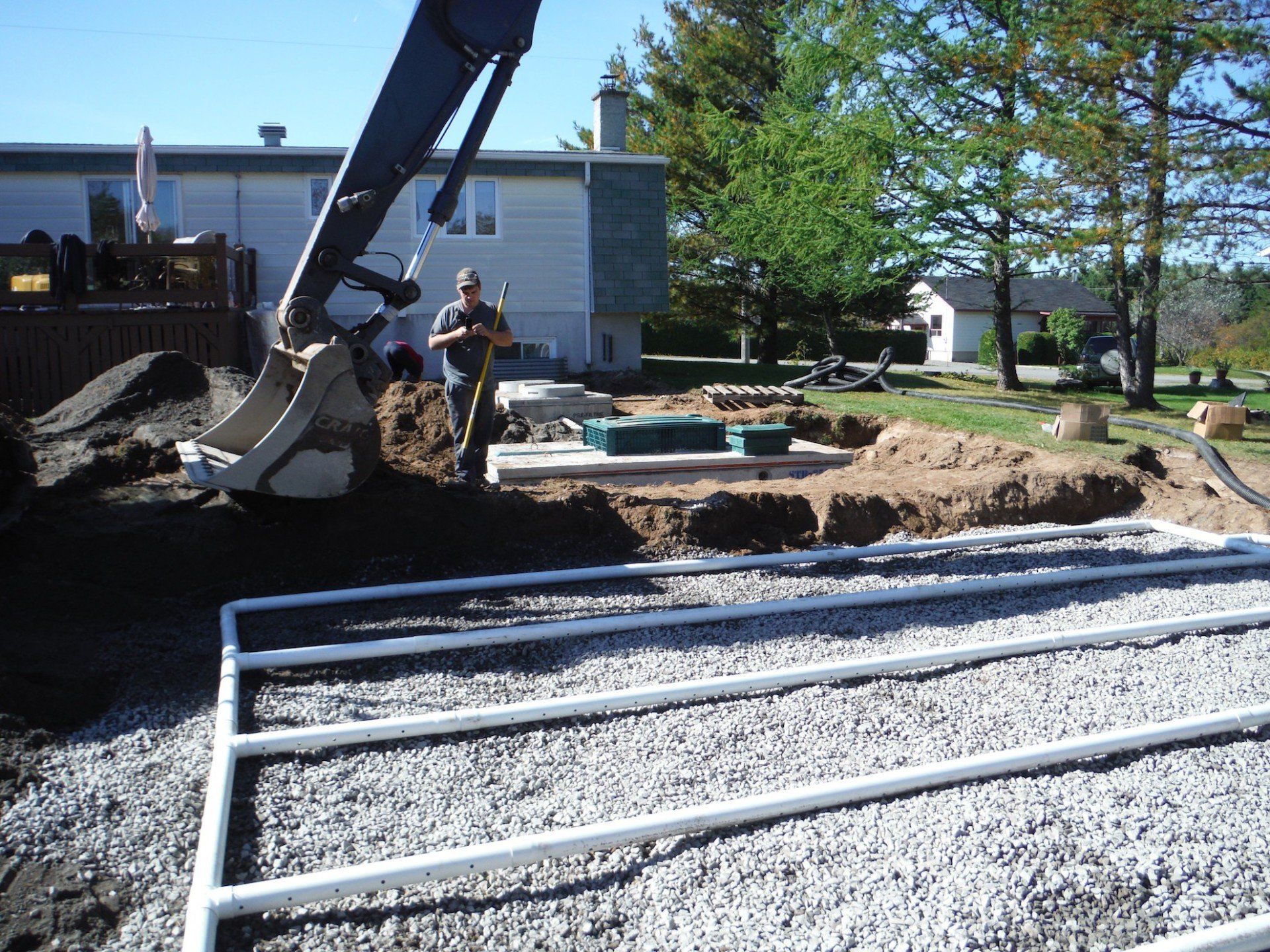 pelle mécanique et ouvrier derrière un champ d'épuration exposé