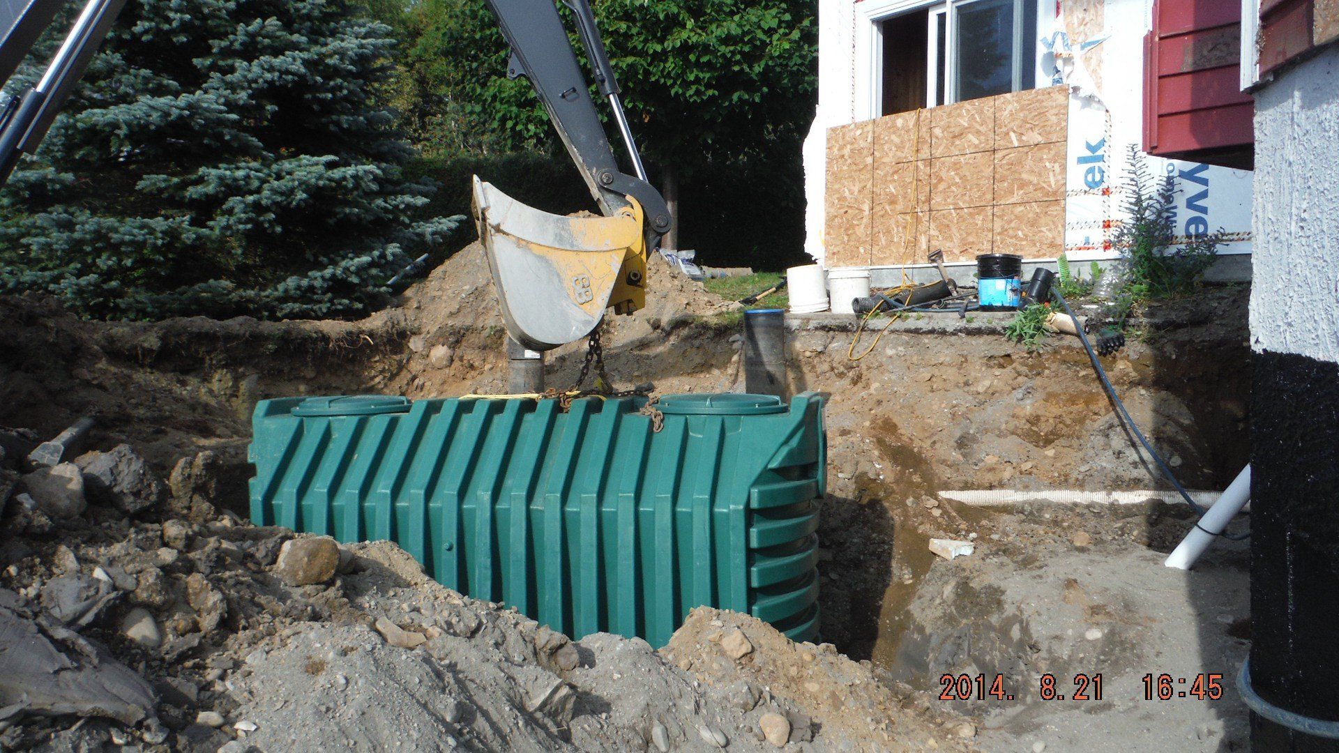 pelle mécanique dépose fosse septique dans trou excavé