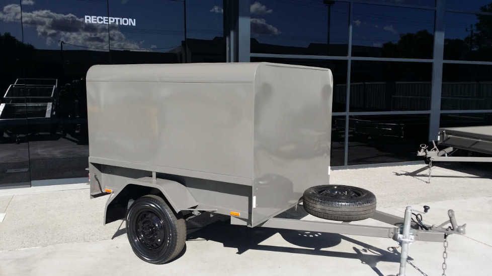 A small trailer for sale in Perth WA is parked in front of a building.