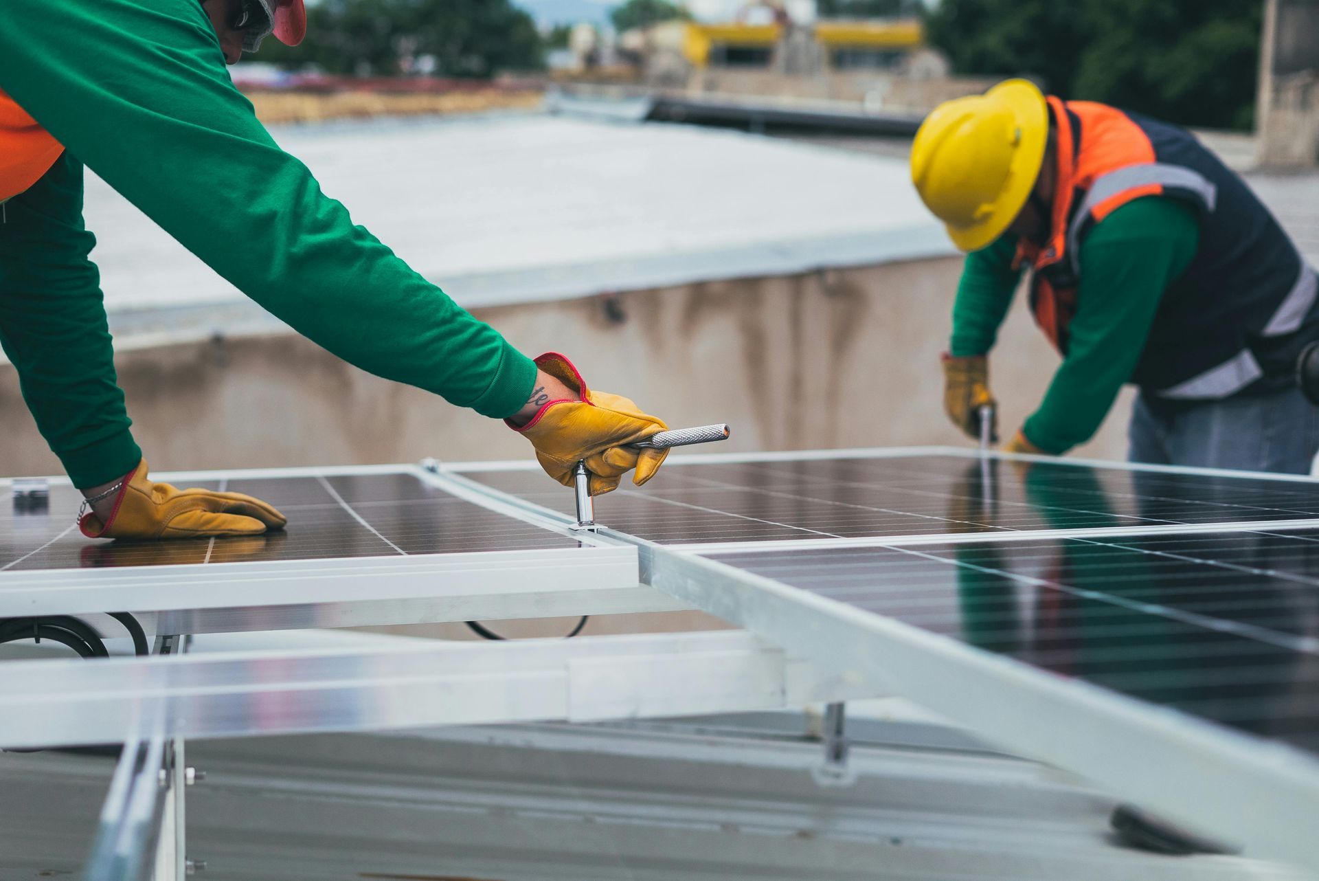 Two men are installing solar panels on the roof of a building.