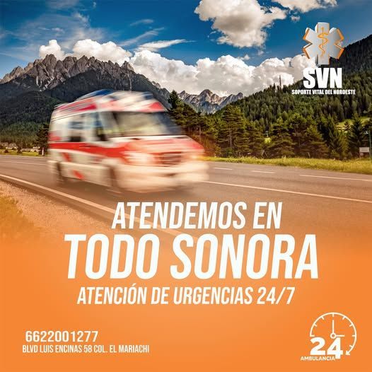 Una ambulancia circula por una carretera con montañas al fondo.