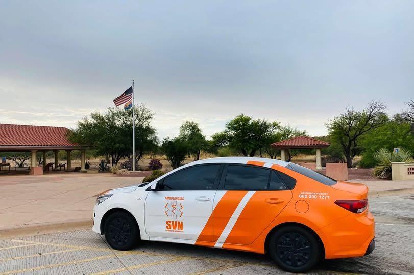 Un coche blanco y naranja está estacionado en un estacionamiento.