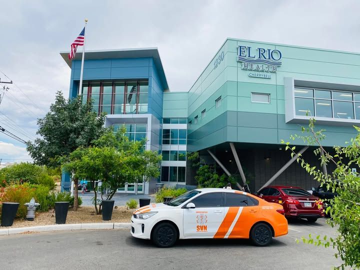 Un coche está estacionado frente a un edificio que dice El Río.