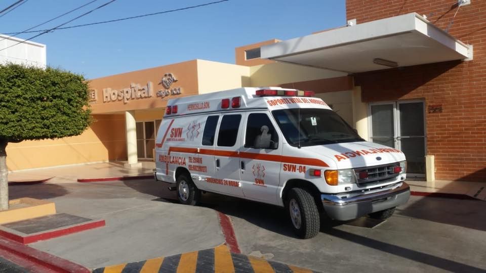 Una ambulancia está estacionada frente a un hospital