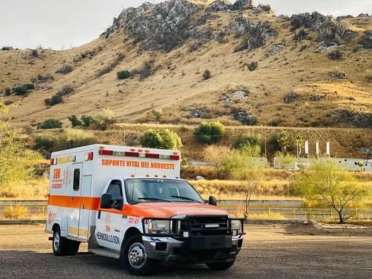 Una ambulancia está estacionada frente a una montaña.