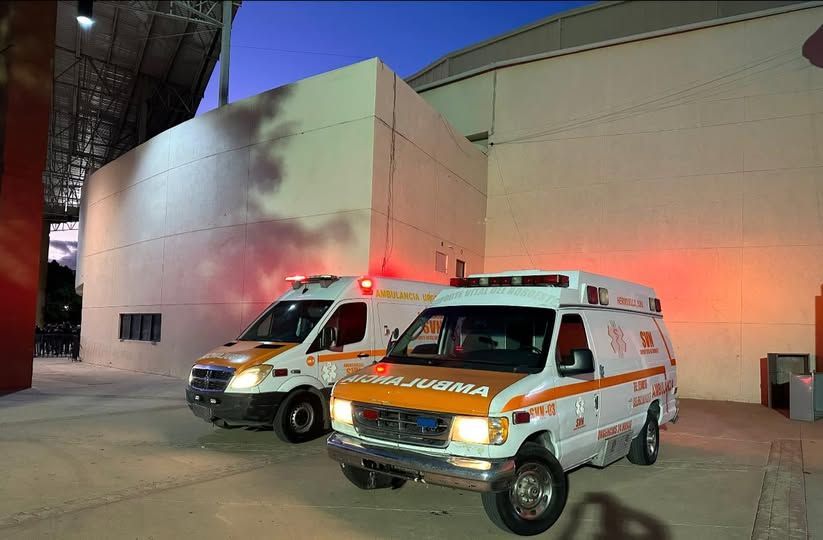 Dos ambulancias están estacionadas frente a un edificio.