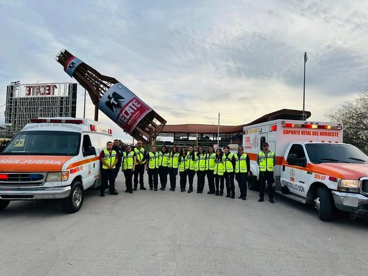 Un grupo de personas de pie frente a una botella gigante de Tecate.