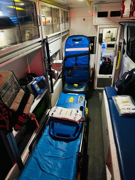 El interior de una ambulancia con una camilla y una silla.