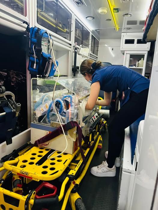 Una enfermera está trabajando con un bebé en una ambulancia.