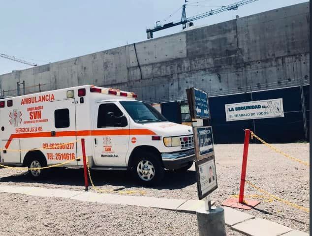 Una ambulancia está estacionada frente a un edificio en construcción.