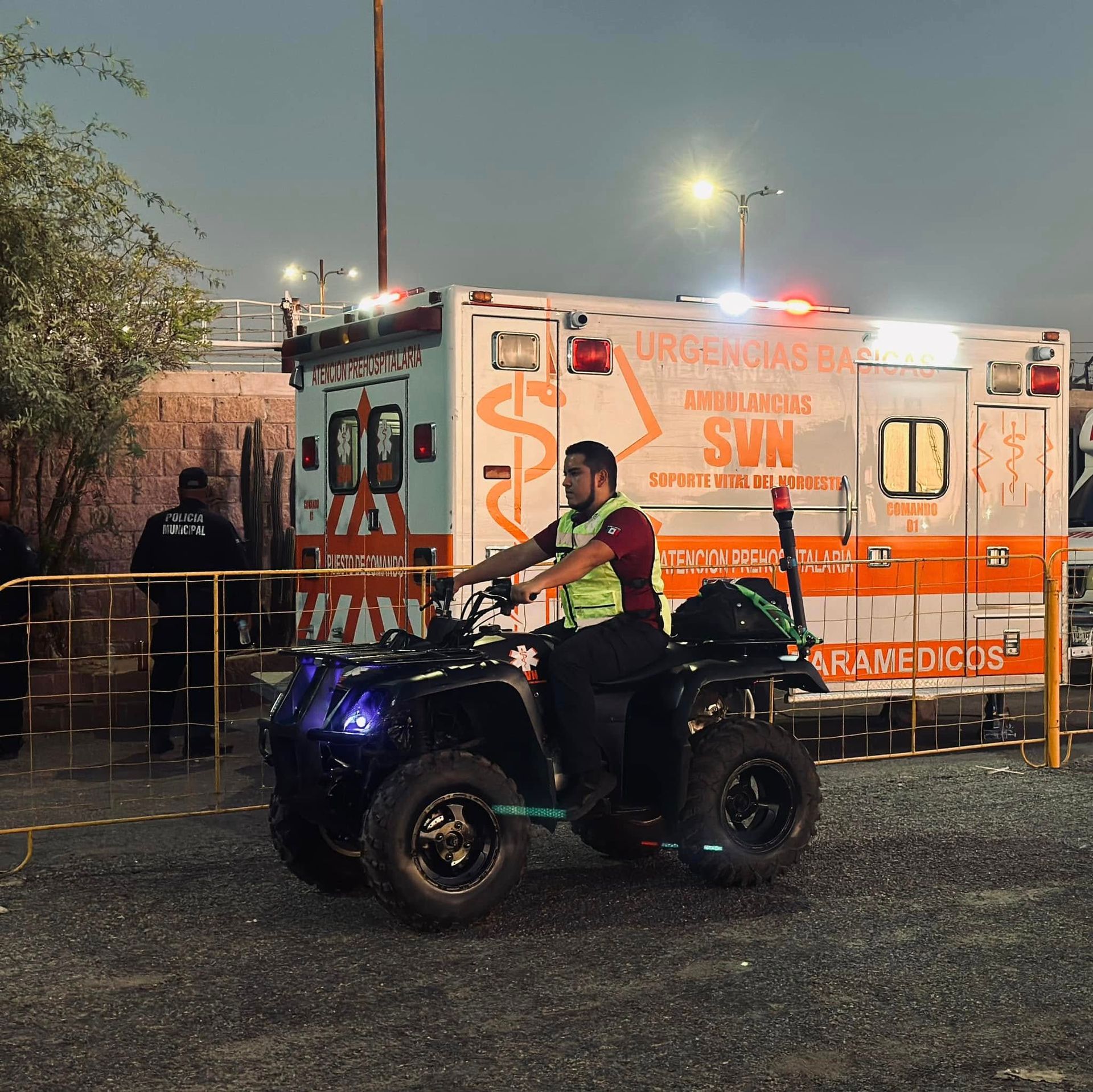 Un hombre conduce un vehículo todo terreno frente a una ambulancia que tiene escrito 
