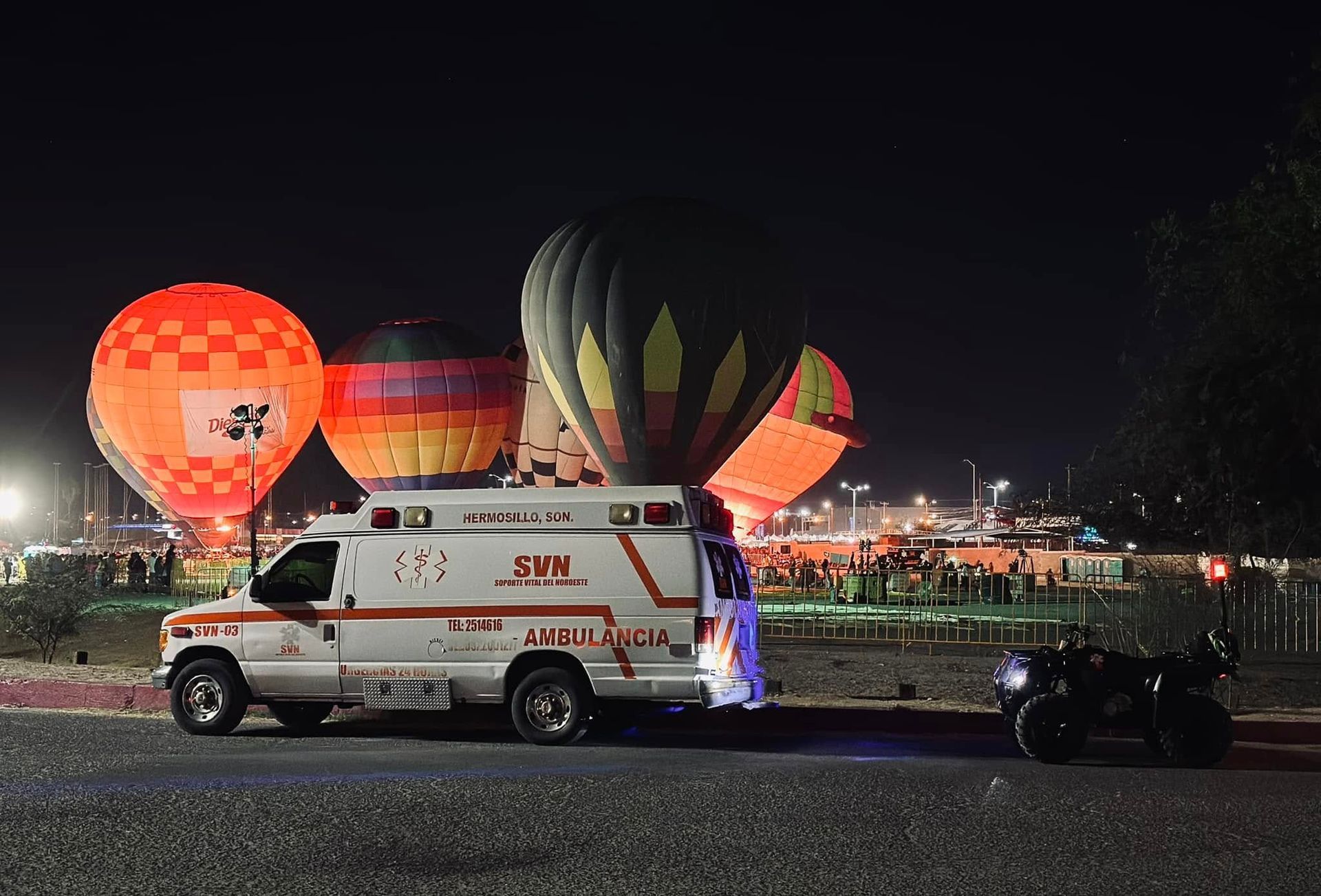 Una ambulancia está estacionada frente a globos aerostáticos.