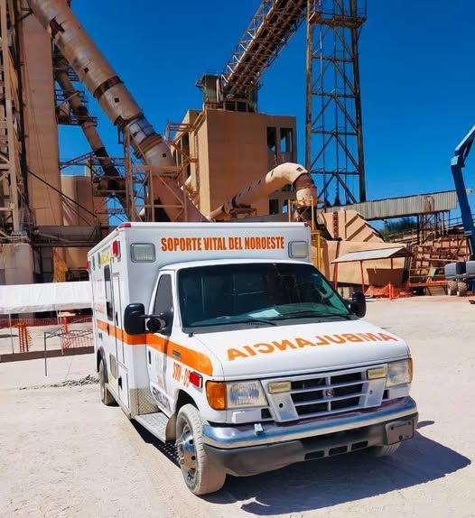 Una ambulancia está estacionada frente a un gran edificio.