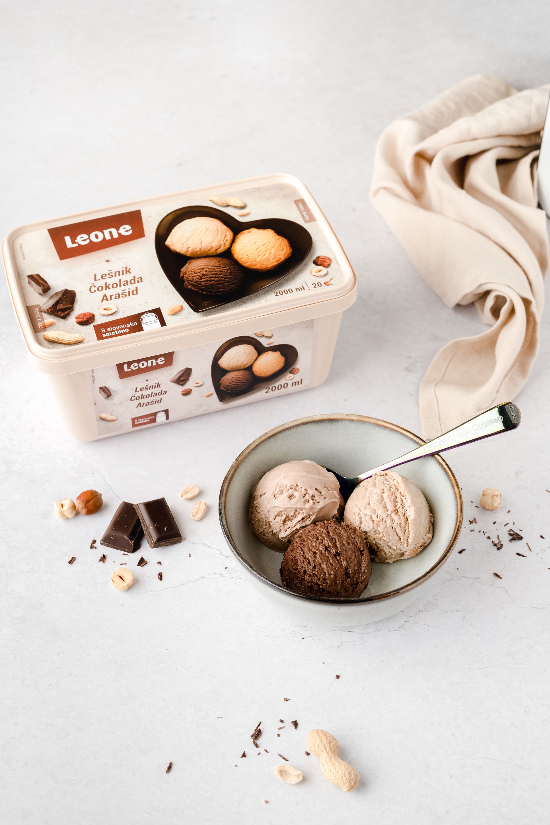 Skleda sladoleda poleg posode s sladoledom.