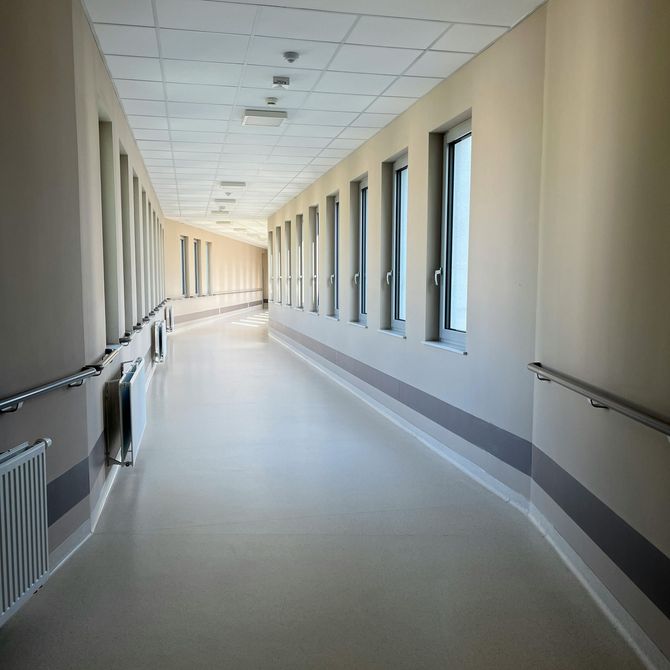 A black painted arrow on a grey surface pointing straight and left, next to a curved red painted stripe.