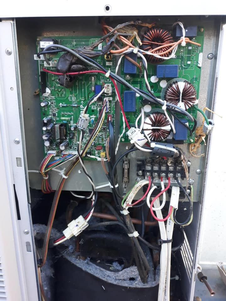 The inside of an air conditioning unit with a lot of wires coming out of it.