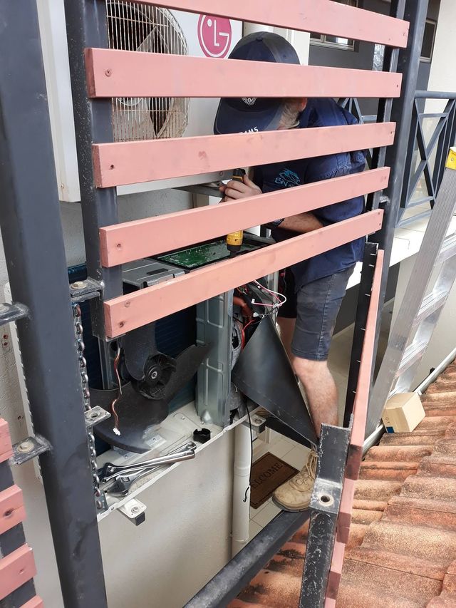 A man is working on a machine behind a fence.