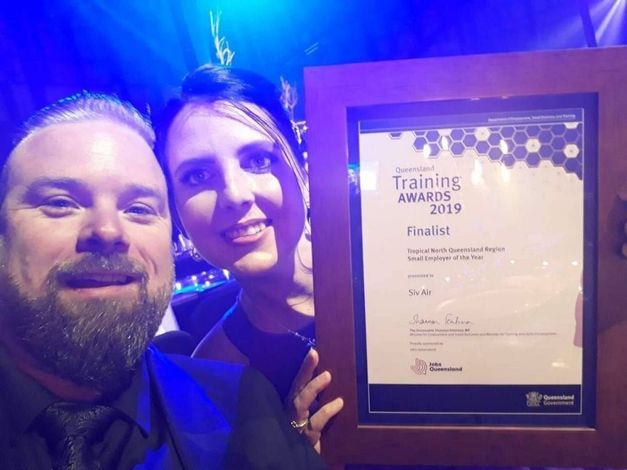 A man and a woman are holding a framed certificate.