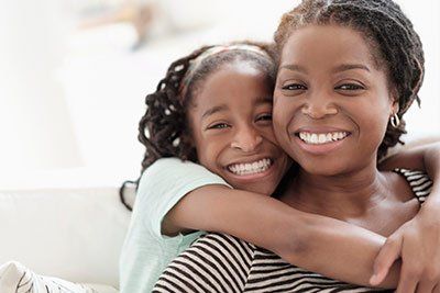 mother and daughter smiling with white teeth