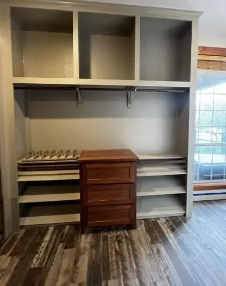 A walk in closet with lots of shelves and drawers.
