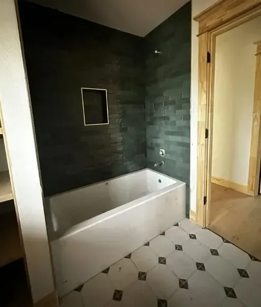 A bathroom with a bathtub and a tiled floor