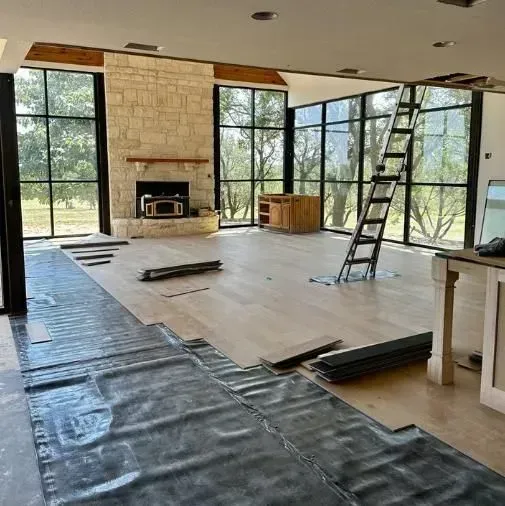 A living room with a fireplace and a ladder in it