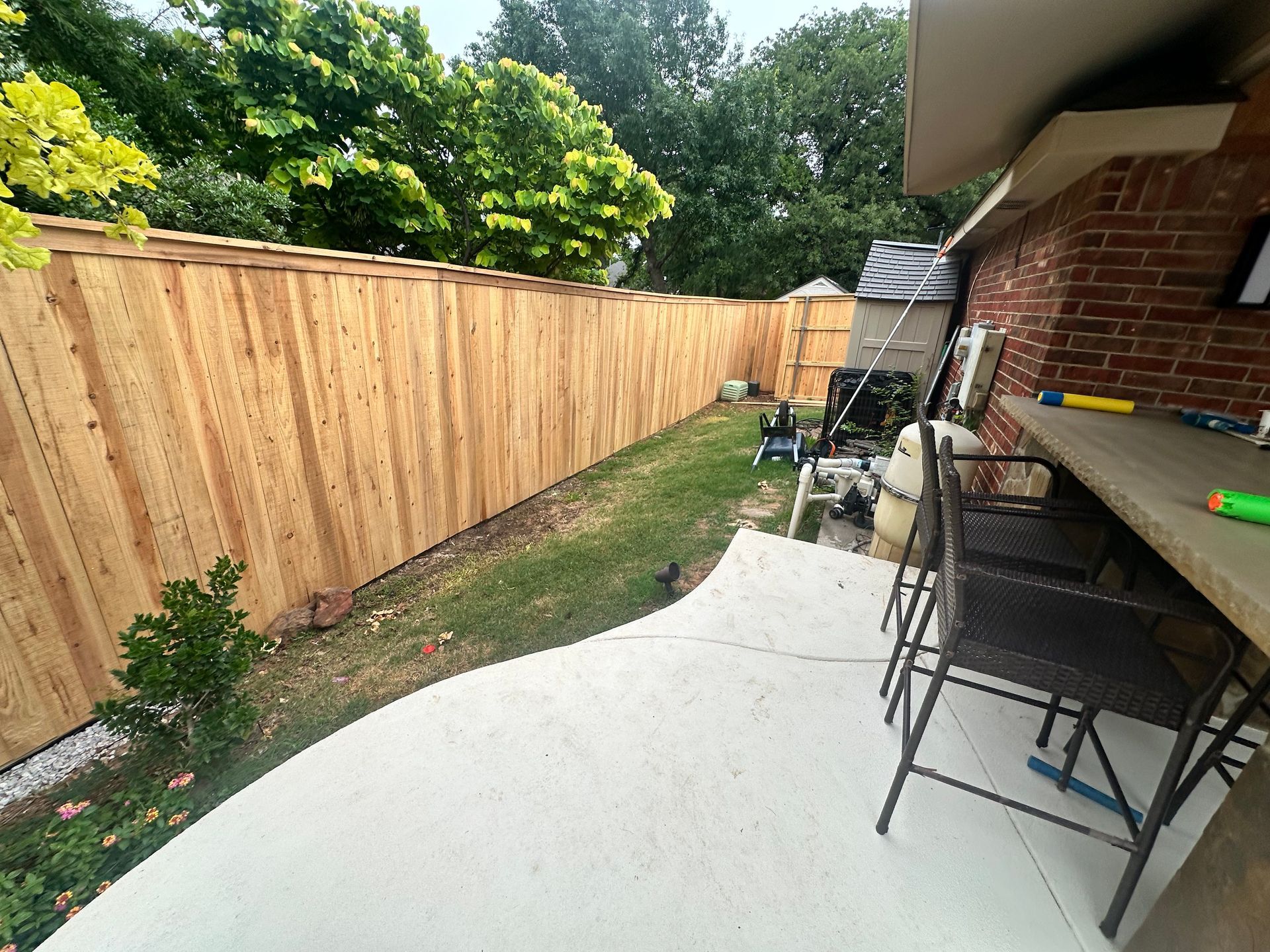 A close up of a wooden fence with trees in the background.