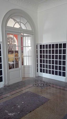 una porta ad arco di color bianco con pannelli di vetro