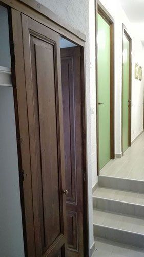 una porta aperta in legno e accanto delle scale