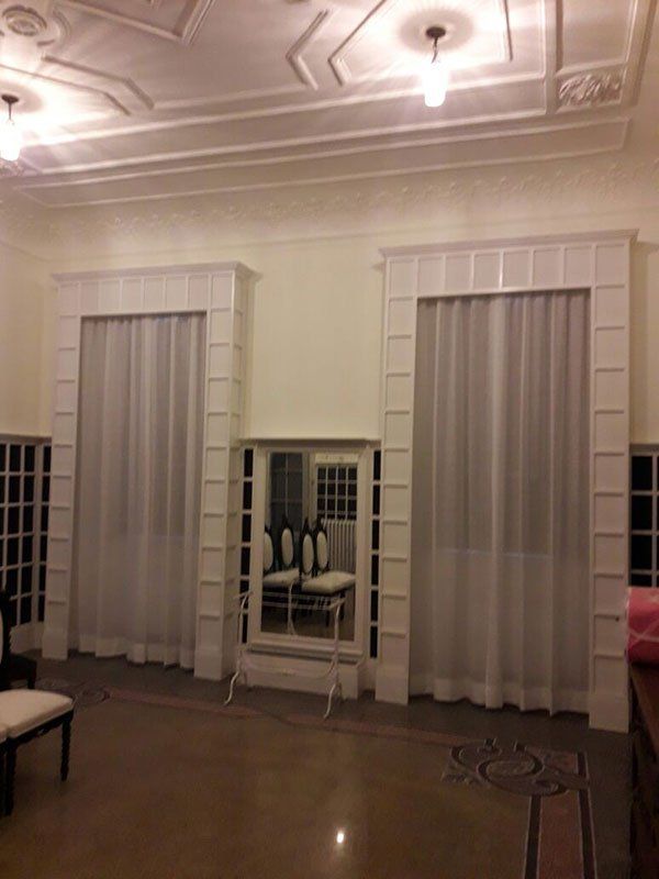 una sala con due finestre con delle tende bianche