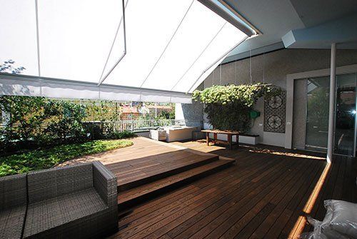 una terraza con il pavimento in legno e un tendone