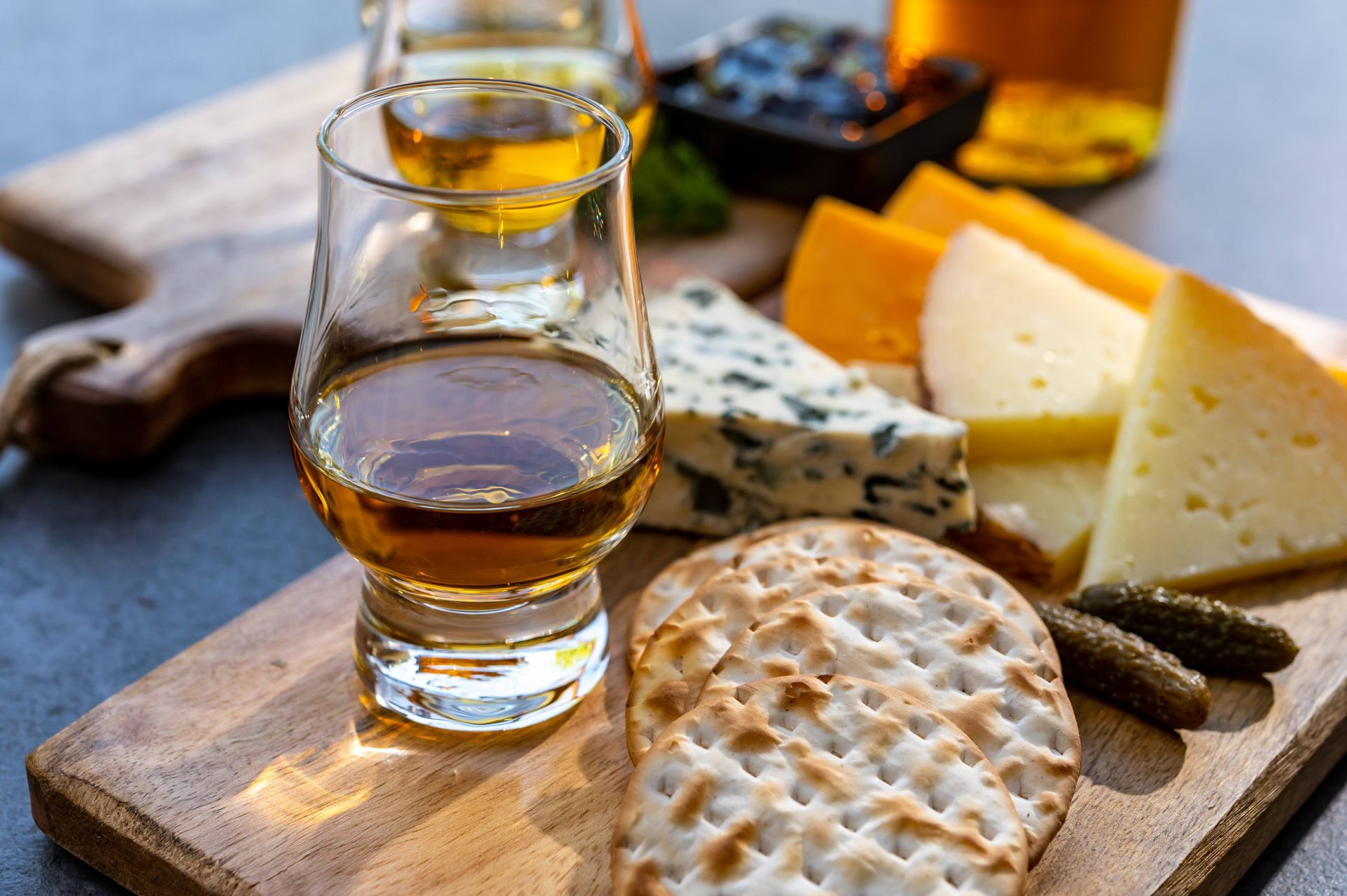 tasting whiskey glasses and sliced cheese pairings on two wood cutting boards at Kentucky River Tours near Frankfort, KY